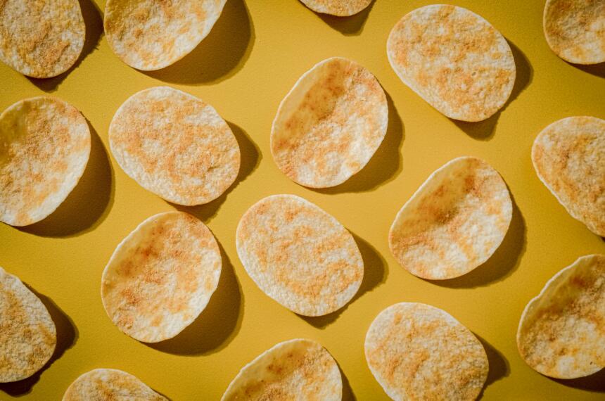 Ovale Kartoffelchips auf gelbem Grund